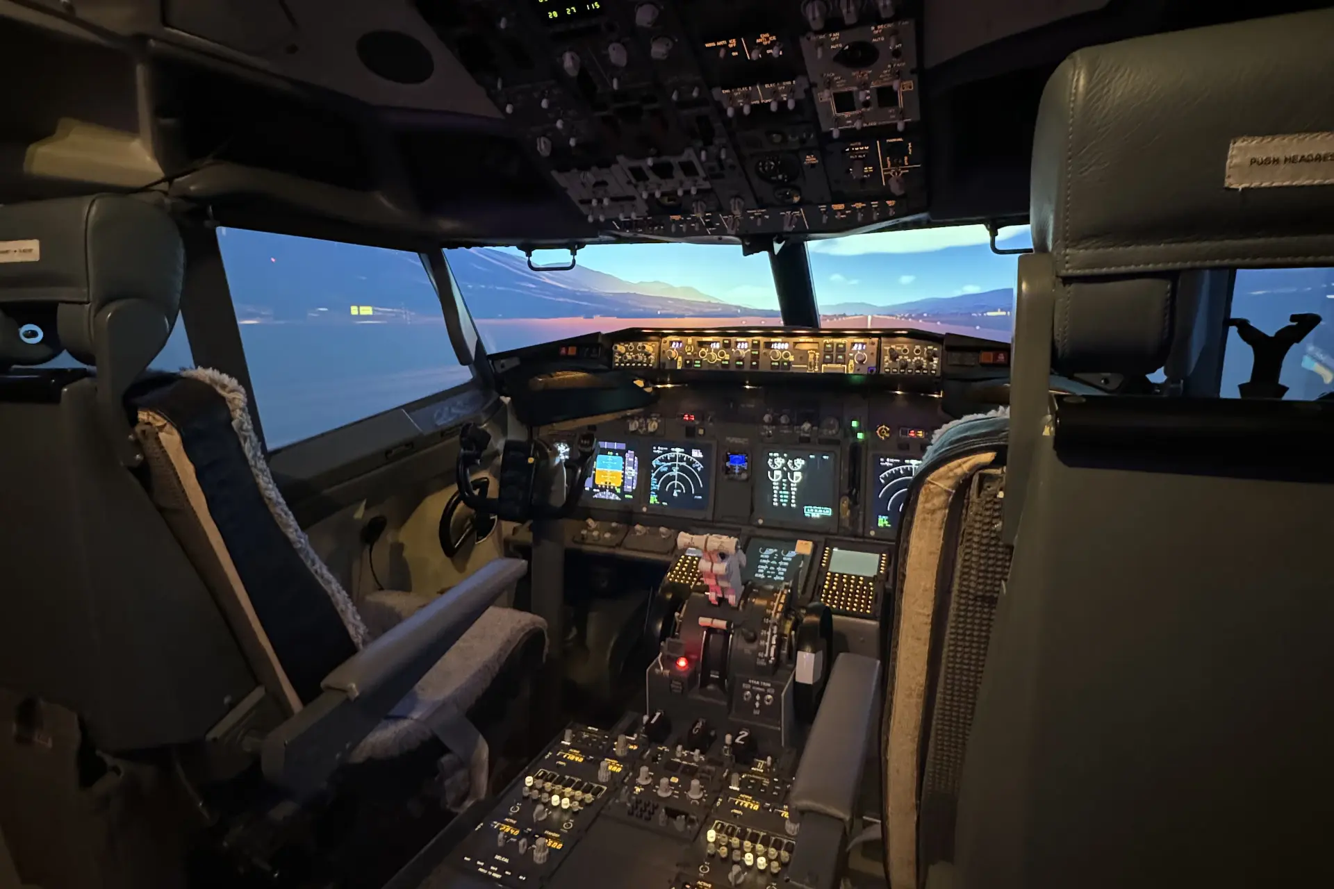 The TG Simulation Boeing 737-800 flight deck from behind the two pilot seats, runway ahead